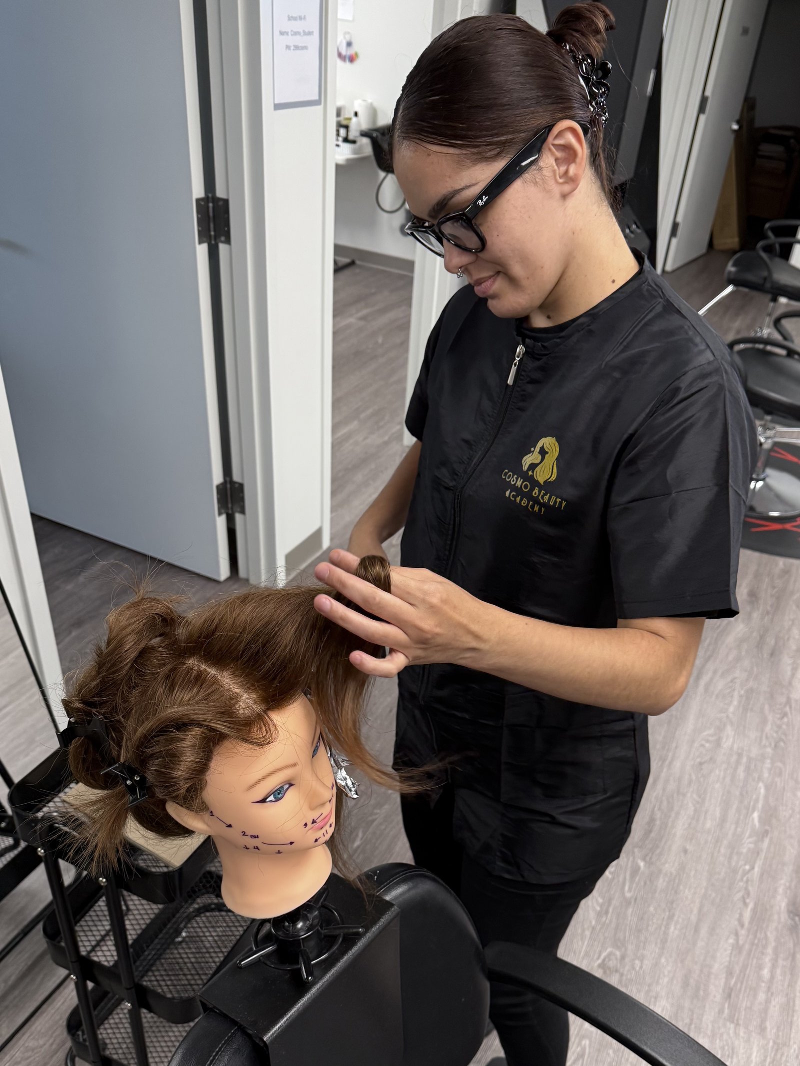 A Cosmo Beauty Academy cosmetology student practicing foil highlighting technique